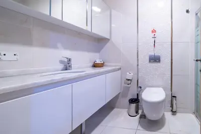 a white bathroom with a toilet and a sink at Mardy Hotel Ataturk Airport in Istanbul