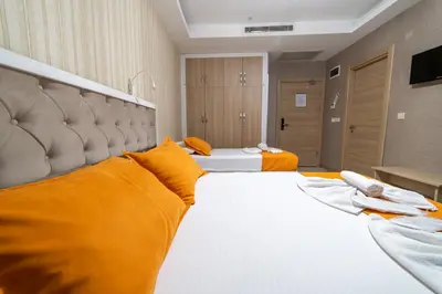 a large hotel room with two beds with orange pillows at Mardy Hotel Ataturk Airport in Istanbul