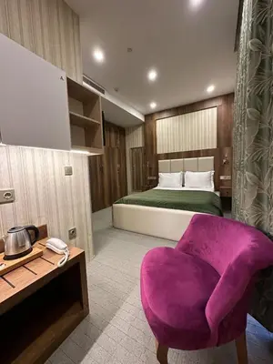 a bedroom with a purple chair and a bed at Mardy Hotel Ataturk Airport in Istanbul