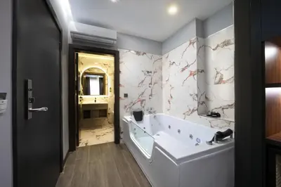 a bathroom with a tub and a sink and a mirror at Second Suit Hotel in Istanbul