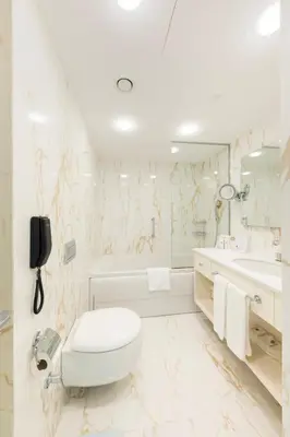 a white bathroom with a toilet and a sink at Hallmark Hotel & SPA Istanbul in Istanbul