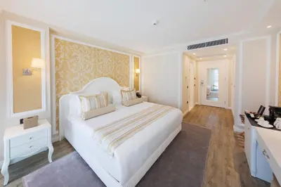 a white bedroom with a large white bed and a desk at Hallmark Hotel & SPA Istanbul in Istanbul