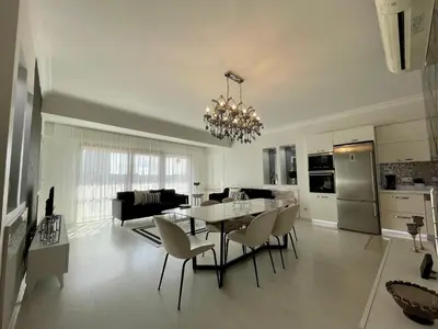 a kitchen and living room with a table and chairs at Kaplan Luxury Family Flat - 3 Bedrooms with air conditioning & heating in the City in Istanbul