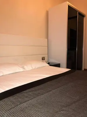 a bedroom with a white bed with a headboard at Aslan Residence in Istanbul