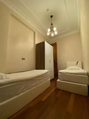a room with two beds and a chandelier in it at Aslan Residence in Istanbul