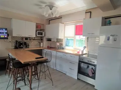 a kitchen with white cabinets and a wooden table at İstanbulda merkezi pitoresk konum müstakil yeni ev in Istanbul