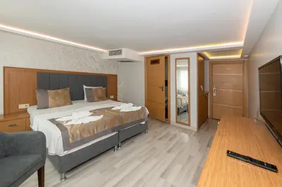 a bedroom with a bed and a couch and a television at GalataportWawhotel in Istanbul