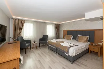 a hotel room with a bed and two chairs at GalataportWawhotel in Istanbul