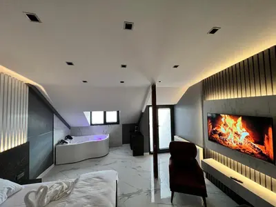 a bedroom with a fireplace and a bed and a tub at BALA HOTEL in Tuzla