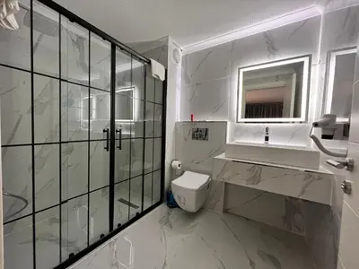 a bathroom with a toilet and a sink and a mirror at BALA HOTEL in Tuzla