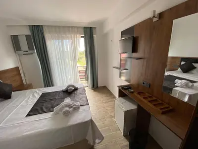 a hotel room with a large bed and a mirror at ATAŞ AQUA OTEL AVŞA in Samanlı