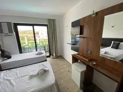 a hotel room with two beds and a mirror at ATAŞ AQUA OTEL AVŞA in Samanlı