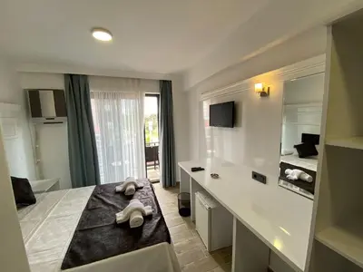 a bathroom with a bed and a sink and a mirror at ATAŞ AQUA OTEL AVŞA in Samanlı