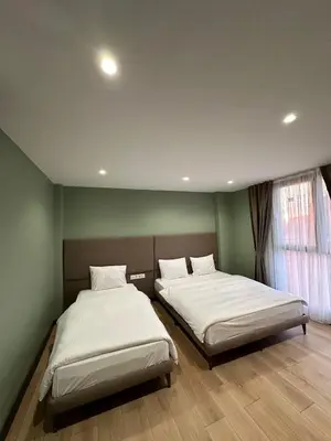 two beds in a room with green walls at Heaven Inn Airport Hotel in Arnavutköy