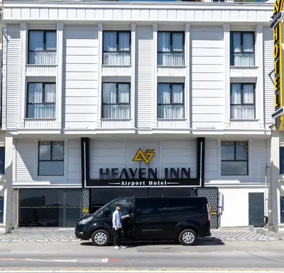 a man standing next to a black van in front of a building at Heaven Inn Airport Hotel in Arnavutköy