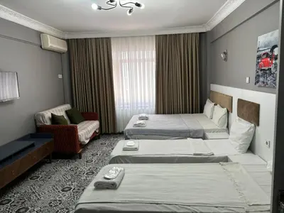 a hotel room with two beds and a chair at Mara Suite Taxim in Istanbul