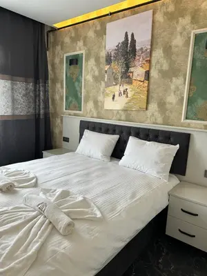 a bedroom with a white bed with paintings on the wall at Mar Boutique Apartment in Istanbul