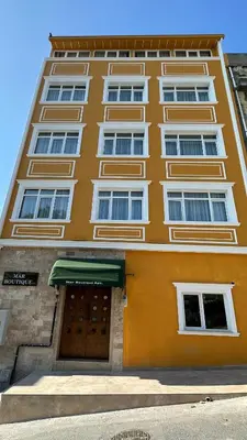 a tall orange building with a door in front of it at Mar Boutique Apartment in Istanbul