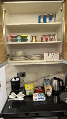 a kitchen counter with plates and dishes on shelves at Mar Boutique Apartment in Istanbul