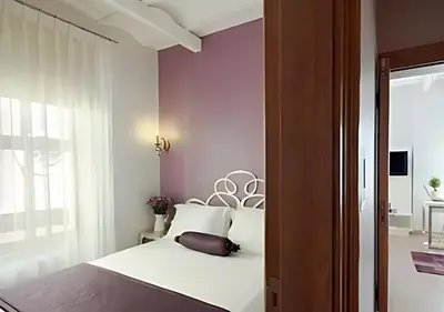 a bedroom with a white bed and purple walls at Baylo Suites in Istanbul