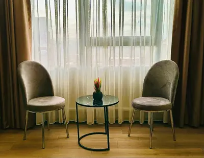two chairs and a table and a vase with flowers on it at Skymoon Istanbul Airport Hotel in Arnavutköy