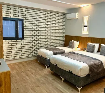 a hotel room with two beds and a brick wall at Skymoon Istanbul Airport Hotel in Arnavutköy