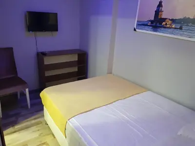 a bedroom with a bed and a chair and a television at EYFEL HOTEL in Istanbul