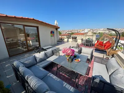 a patio with a blue couch and a table with flowers at Waterfront Apartment by the Tram- Terrace with Dome & Golden Horn View in Fatih in Istanbul
