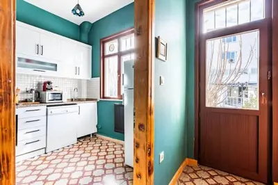 a kitchen with green walls and white cabinets and a door at Waterfront Apartment by the Tram- Terrace with Dome & Golden Horn View in Fatih in Istanbul