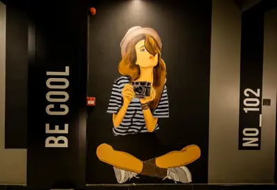 a painting of a woman sitting on the floor holding a camera at Ava Istanbul City Center Hotel in Istanbul