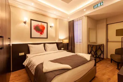 a bedroom with a large bed and a chair at Lilium Luxury Suites in Istanbul