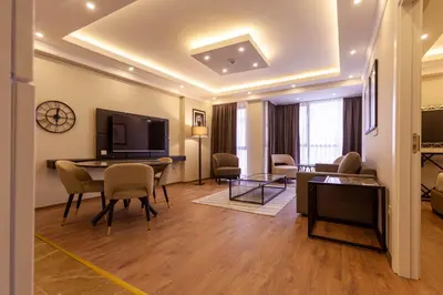 a living room with a table and chairs and a television at Lilium Luxury Suites in Istanbul