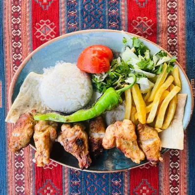 a plate of food with rice and vegetables and meat at Ottoman Luxury Hotel in Istanbul