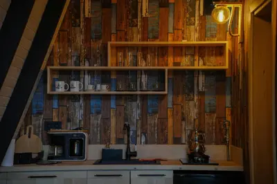 a kitchen with a shelf with books on it at Bungalov Maşukiye Villa in Kartepe