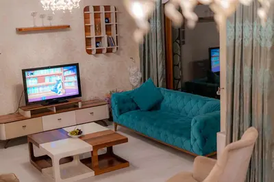 a living room with a blue couch and a tv at Bungalov Maşukiye Villa in Kartepe