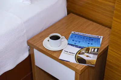 a cup of coffee on a bedside table with a magazine at The Hera Platinum Hotel in Istanbul