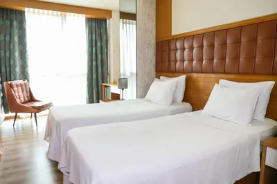 a hotel room with two beds and a chair at The Hera Platinum Hotel in Istanbul