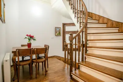a dining room with a table and a spiral staircase at Historical Greco-Ottoman Pavilion near Tram in Fatih in Istanbul