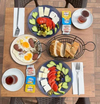 a table with plates of breakfast food on it at Olen Uskudar Hotel in Istanbul