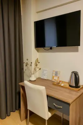 a desk with a white chair and a television on a wall at Elite Marmara Boutique Hotel Sultanahmet in Istanbul