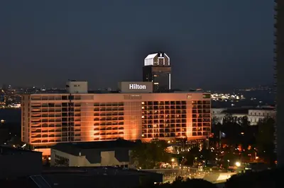 a hilton hotel with a lit up building at night at sevim suites With a sea view in nişantaşı in Istanbul