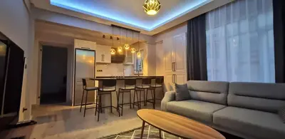 a living room with a couch and a kitchen at Tam Merkezde Yepyeni Bir Daire in Istanbul