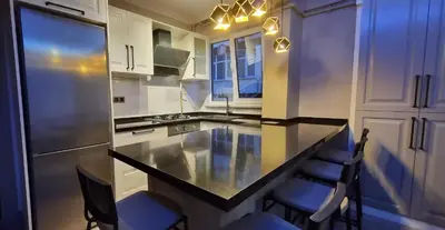 a kitchen with a counter with chairs and a refrigerator at Tam Merkezde Yepyeni Bir Daire in Istanbul