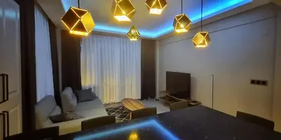 a living room with a table and chairs and lights at Tam Merkezde Yepyeni Bir Daire in Istanbul