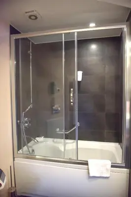 a bathroom with a shower and a bath tub at Denizatı Plus Hotel in Istanbul