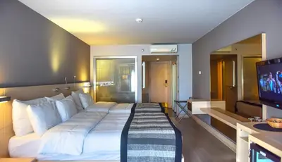 a hotel room with a large bed and a television at Denizatı Plus Hotel in Istanbul