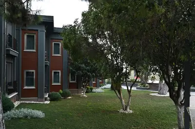 a building with trees in front of a yard at Denizatı Plus Hotel in Istanbul