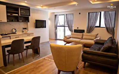 a living room with a couch and a table and chairs at Parla Suite Hotel in Esenyurt