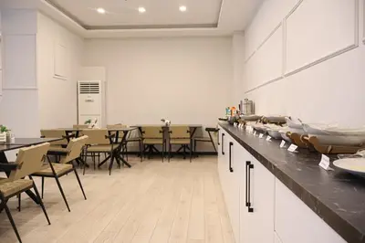 a kitchen with a counter and tables and chairs at HOME PLUS Hotel in Istanbul