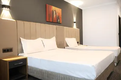 a hotel room with two beds with white pillows at HOME PLUS Hotel in Istanbul